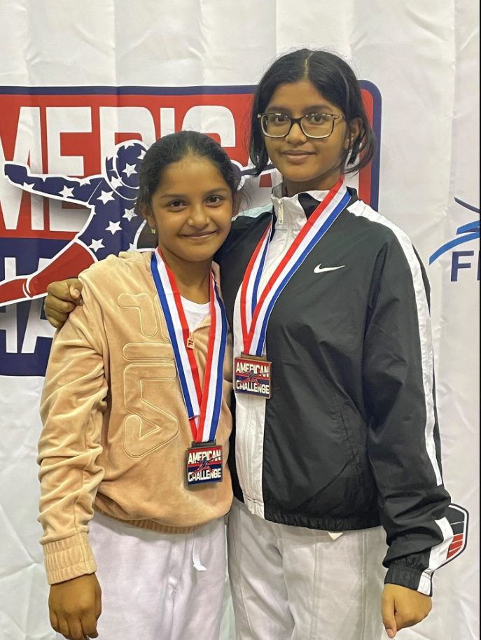 Two young students in track suits with medals around their necks