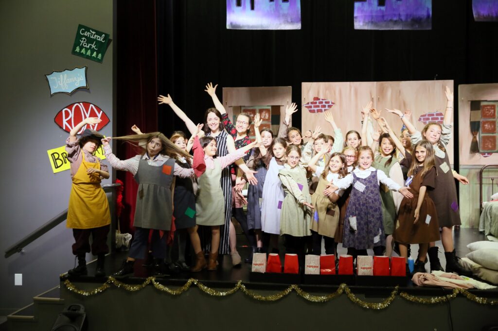 Students performing on a theater stage.