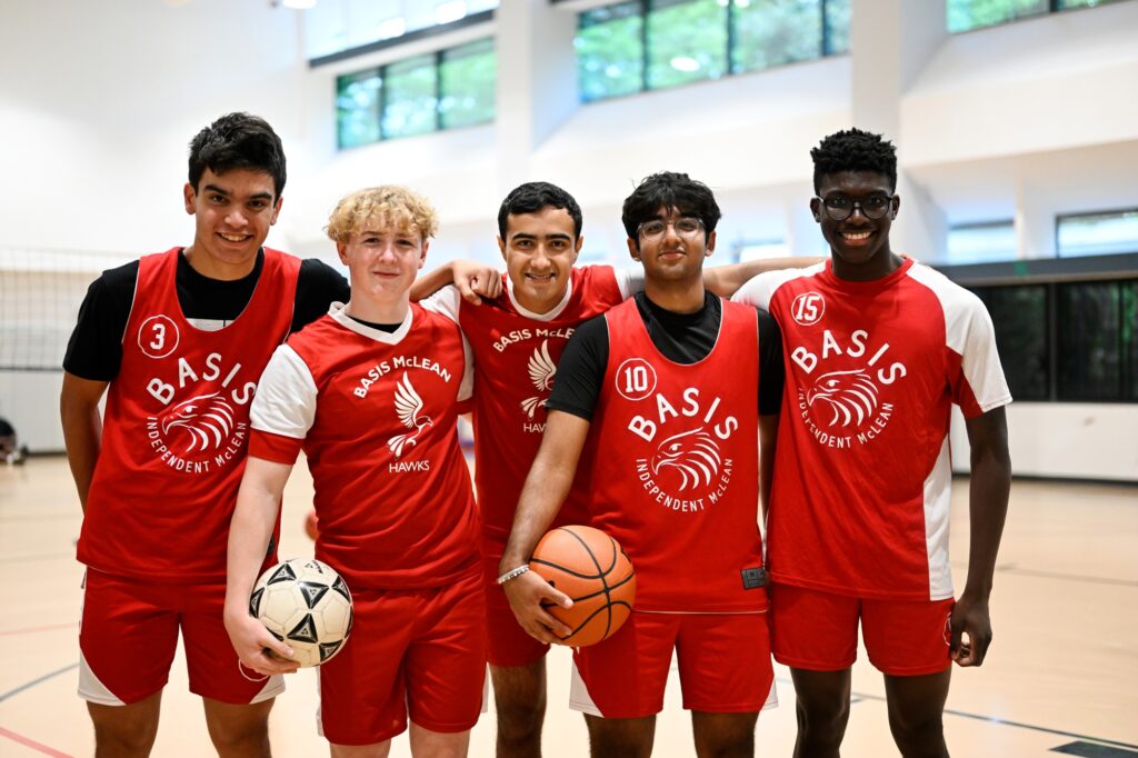 Students posing for the camera in basketball jerseys.