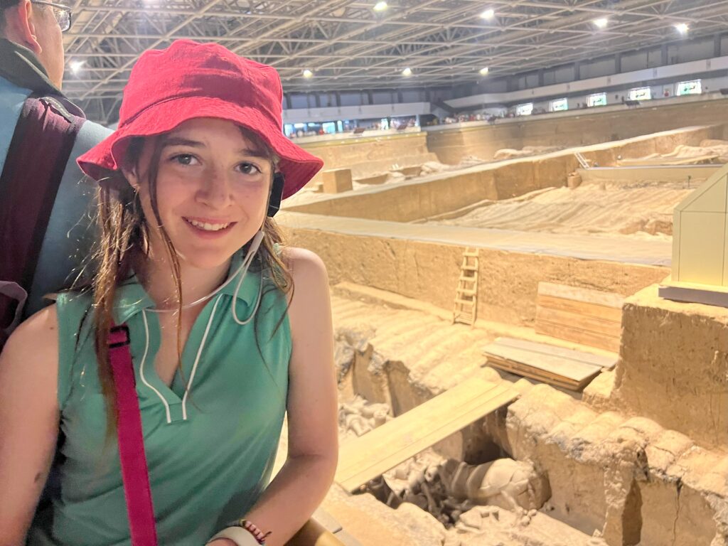 student poses standing above the terracotta warrior museum