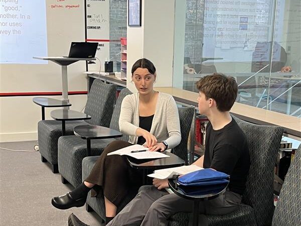 Ms. Bond discussing topics with a student.