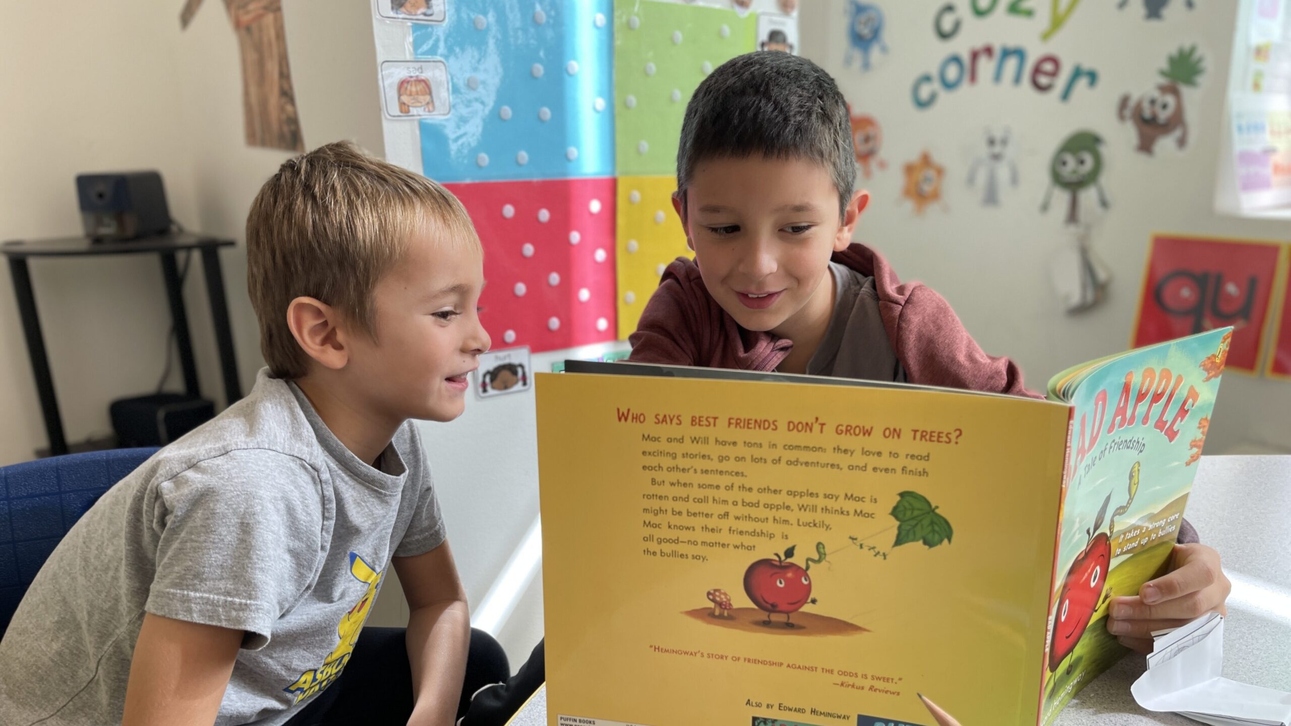 two male elementary school students read a picture book together