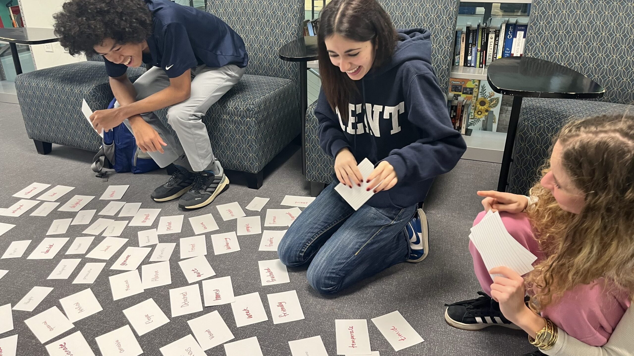 high school students in English class doing an activity with notecards spread across the floor