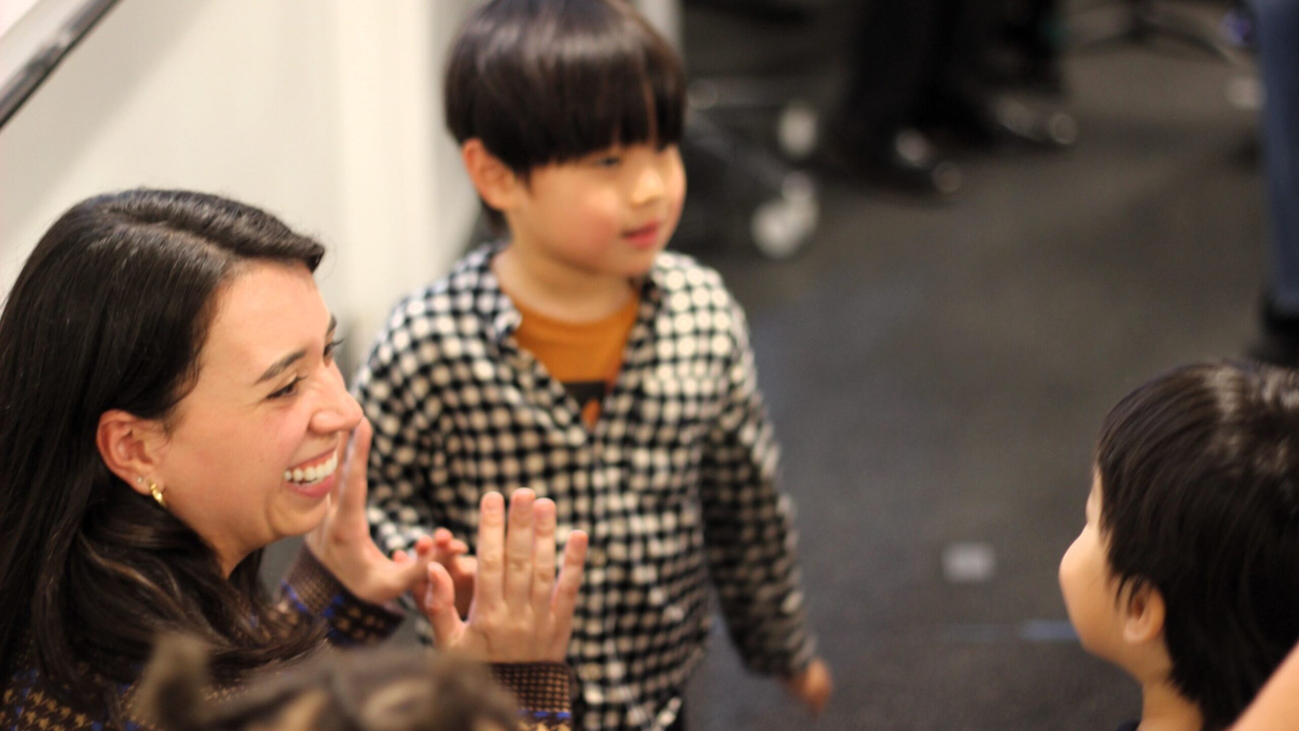 Ms. Bandarenko interacts smiling with two early learning program students