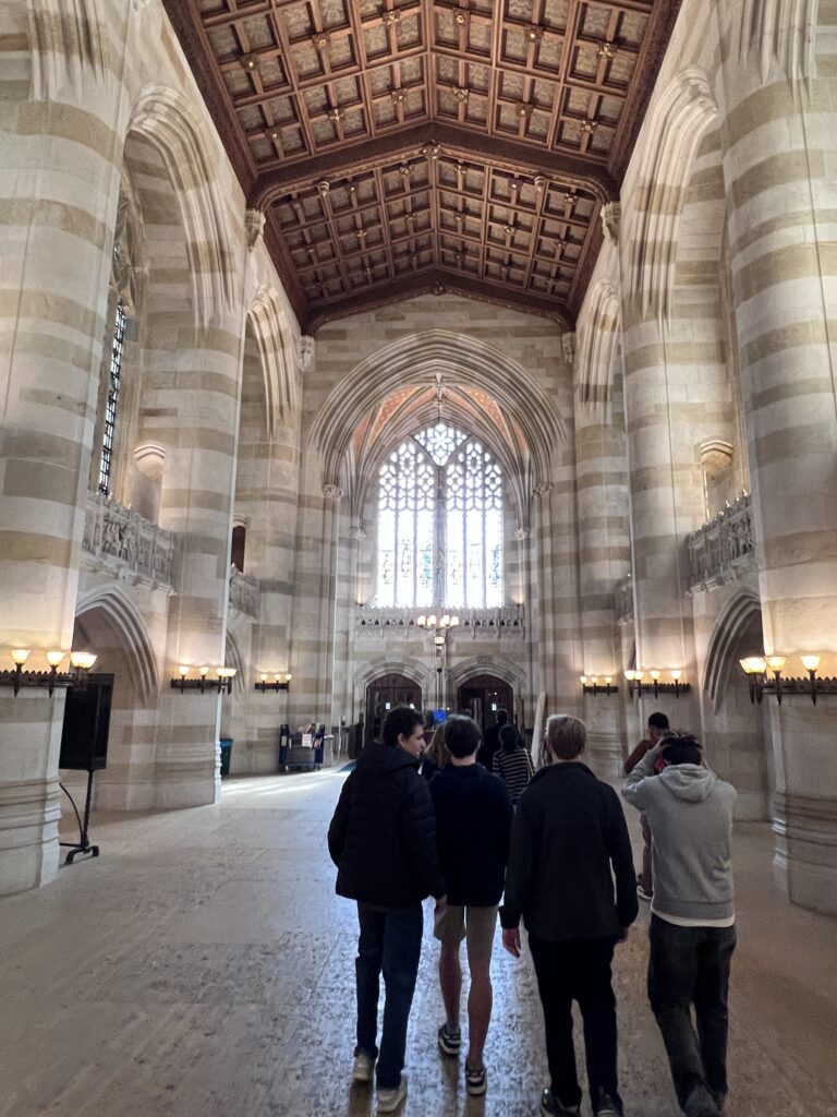 four students walk through Yale University on a college tour.